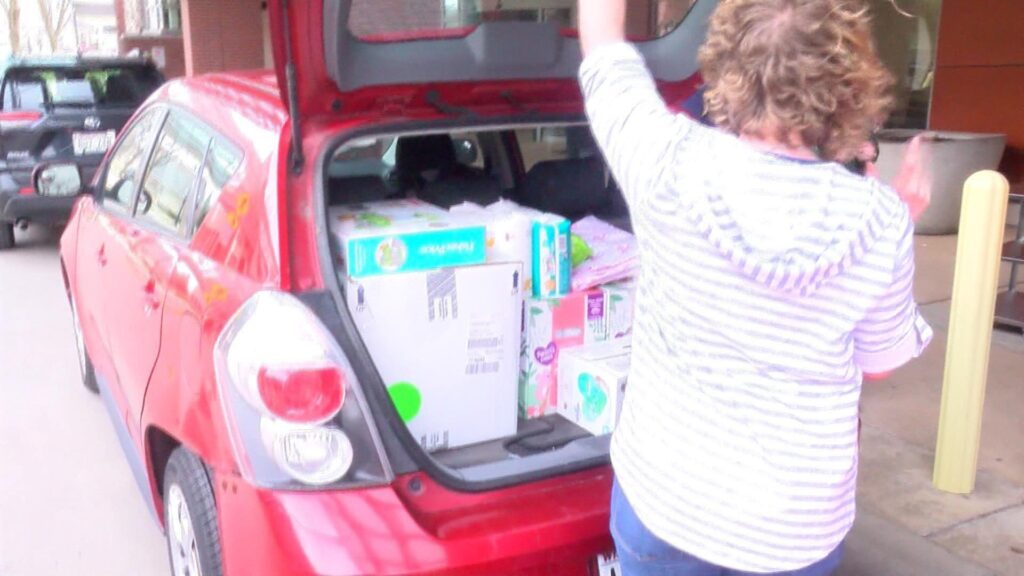 woman closing trunk with car full of diapers BabiesAndBeyondWi.org - Baby Care Packages